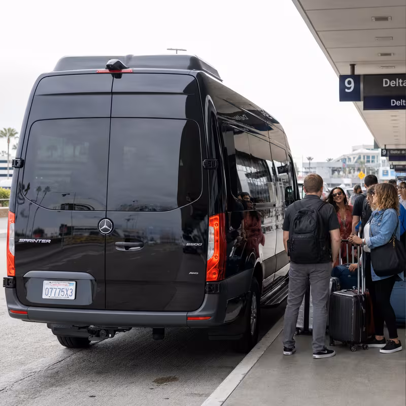 Group boarding a white charter bus for Airport Transportation transportation in San Diego